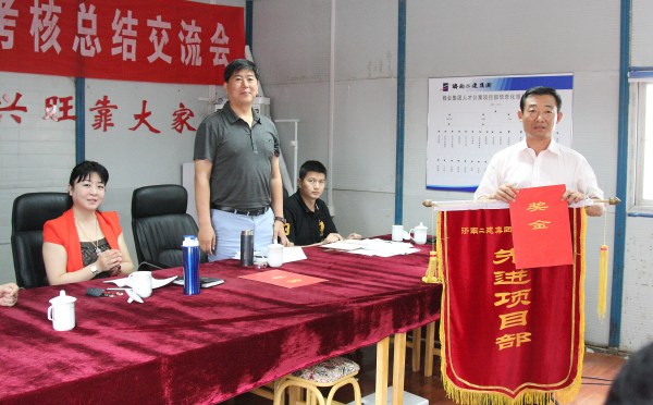 1王董事长为5月份薪酬考核第一名的第三工程分公司人才公寓项目部颁发锦旗及奖金