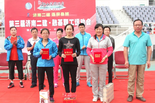 12宋立新副总经理为获得女子组跳远比赛第一名的十分公司代表队王珍、第二名的六分公司代表队张萌、第三名的五分公司代表队宋丽丽颁发证书和奖品